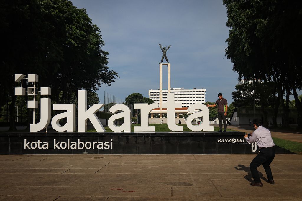 Warga berfoto di instalasi logo +Jakarta atau PlusJakarta di Taman Lapangan Banteng, Jakarta Pusat, Selasa (13/12/2022).