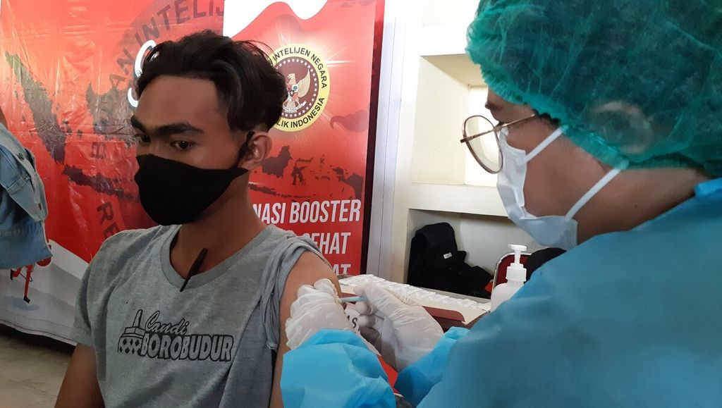 Petugas vaksinasi menyuntikkan vaksin Covid-19 dosis ketiga, atau vaksinasi penguat (<i>booster</i>), kepada penerima vaksinasi penguat di area Kantor DPRD Provinsi Bali, Kota Denpasar, Rabu (12/1/2022). Bali termasuk daerah di Indonesia yang mulai memberikan vaksinasi penguat kepada masyarakat yang sudah memenuhi syarat sebagai penerima vaksin Covid-19 dosis ketiga.