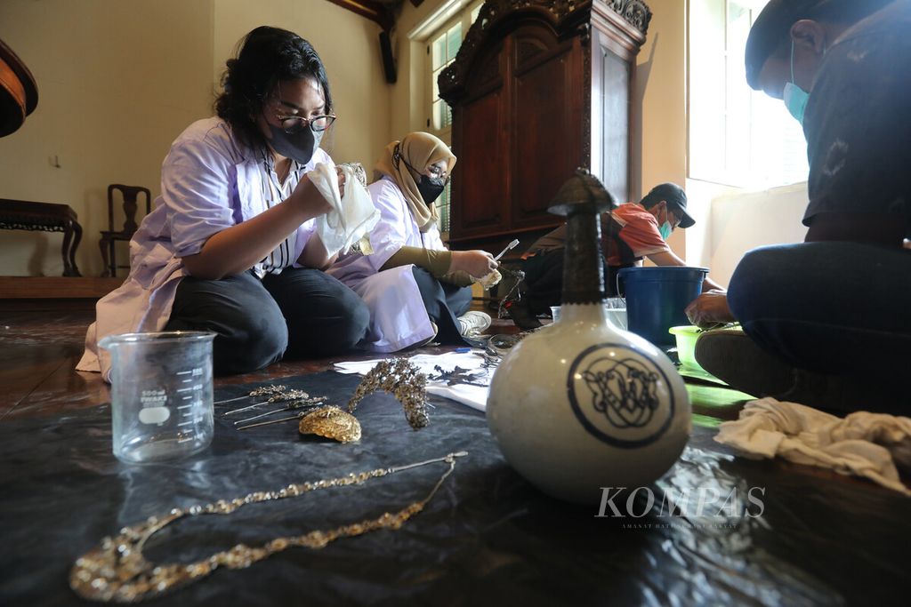Tenaga teknis dibantu mahasiswi magang dari Jurusan Arkeologi Universitas Jambi membersihkan koleksi perhiasan Betawi kuno dari abad dan keramik era VOC dari abad ke-18 di Museum Sejarah Jakarta, Senin (26/9/2022). 