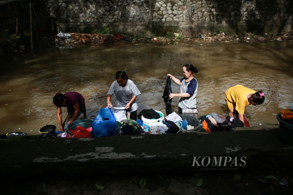 Warga mencuci pakaian di saluran air di Selapanjang Jaya, Kecamatan Neglasari, Kota Tangerang, Banten, Jumat (18/11/2022).
