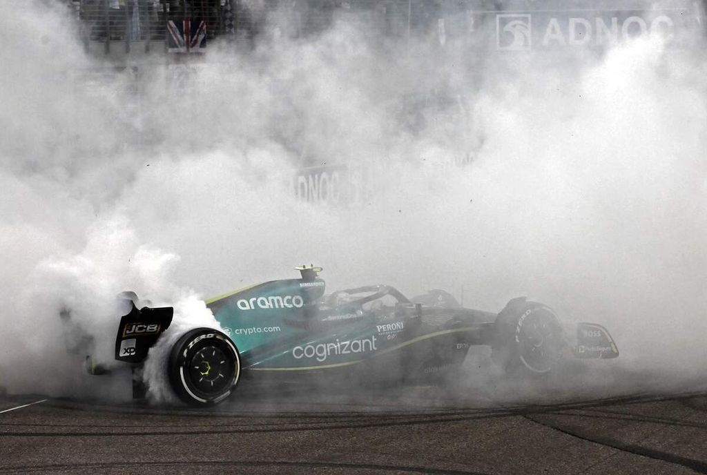 Pebalap Aston Martin Sebastian Vettel melakukan <i>doughnut</i>, aksi berputar di lintasan yang menimbulkan asap tebal, sebagai penanda pamit seusai balapan terakhir dalam kariernya, di Grand Prix Formula 1 Abu Dhabi, di Sirkuit Yas Marina, Uni Emirat Arab, Minggu (20/11/2022).