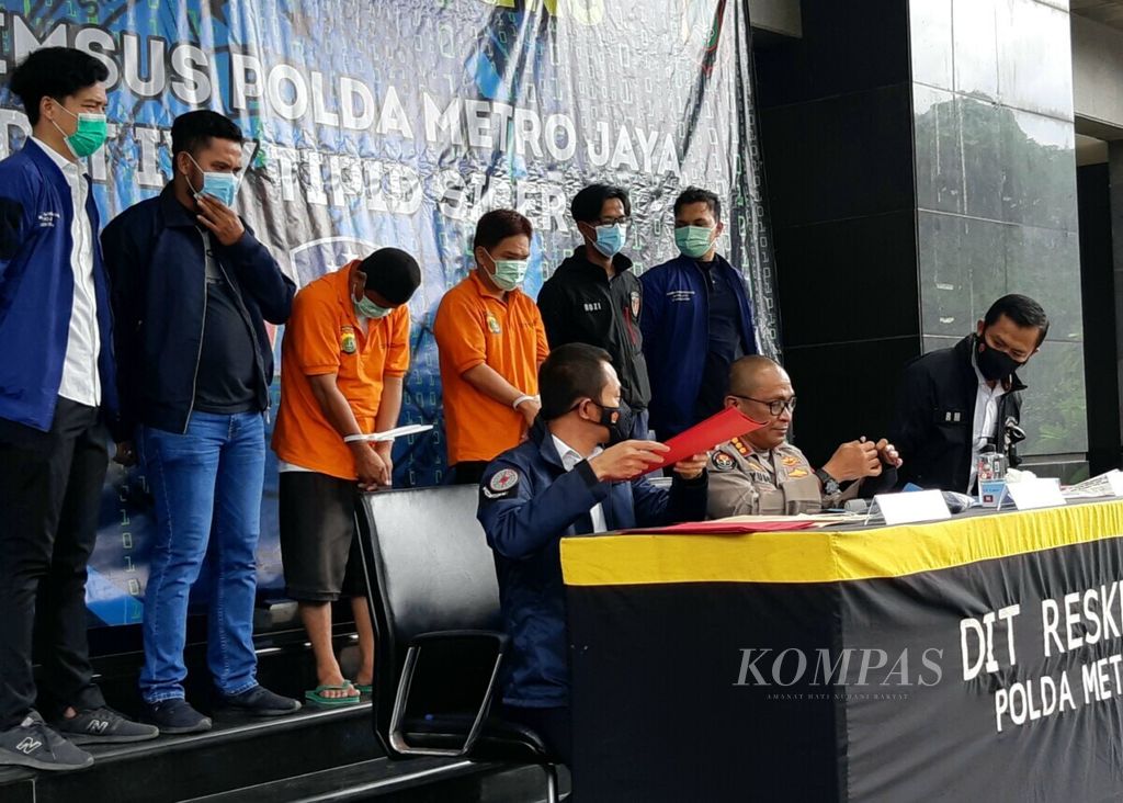 Personel Kepolisian Daerah Metro Jaya, Senin (14/12/2020), dalam konferensi pers di Jakarta mengawal dua pelaku ujaran kebencian.