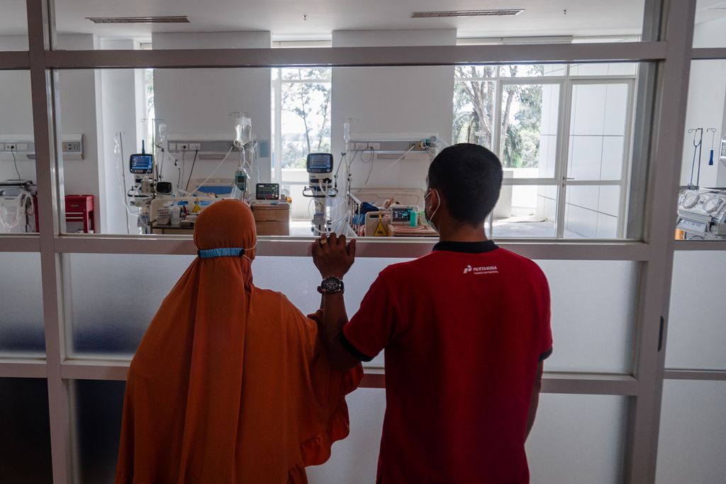 Pasangan suami istri, Eva Nurmala (34) dan Lamhari (39), melihat anak ketiga mereka, Nasifa (2,8), dari balik kaca di ruang ruang perawatan intensif khusus anak (PICU) di Rumah Sakit Badan Pengusahaan Batam, Kota Batam, Kepulauan Riau, Kamis (27/10/2022). Nasifa dirawat di rumah sakit tersebut sejak satu bulan lalu karena mengidap gangguan ginjal akut.