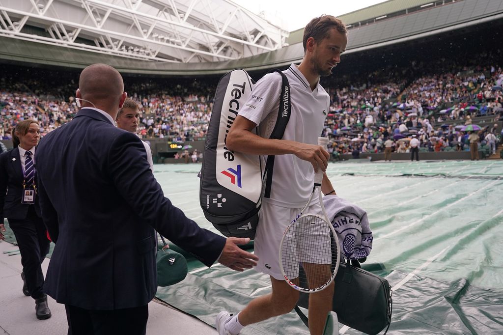 Petenis Rusia, Daniil Medvedev (kanan), meninggalkan Lapangan 1 All England Tennis Club pada ajang Grand Slam Wimbledon 2023 di Wimbledon, Inggris Rabu (5/7/2023). Laga babak pertama tunggal putra versus Arthur Fery (Inggris) itu sempat ditunda akibat hujan.