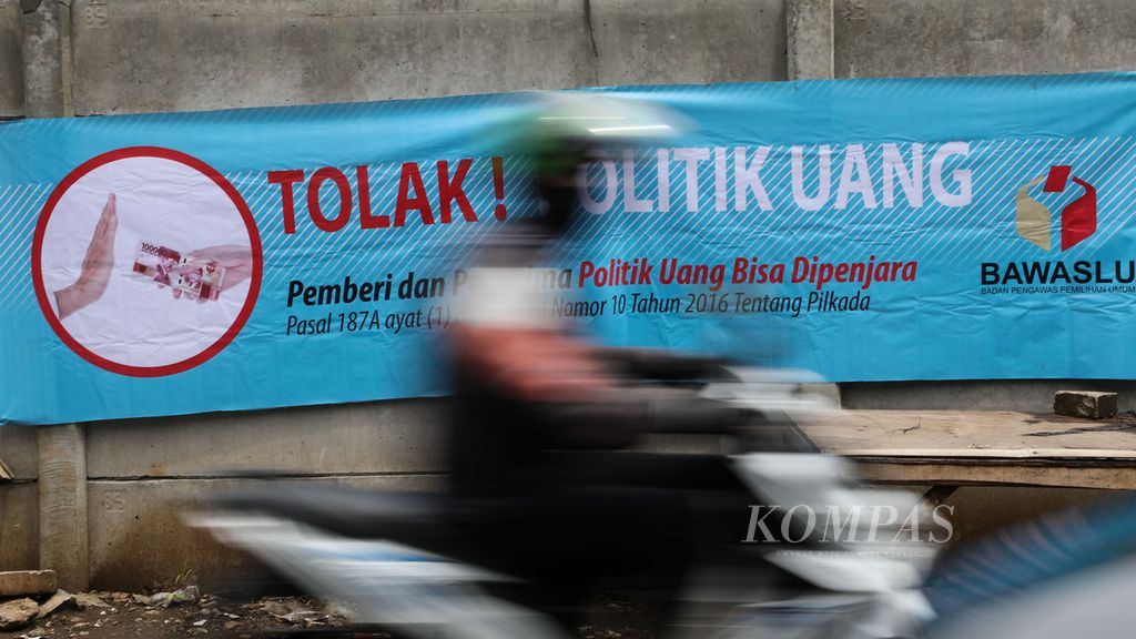Spanduk ajakan untuk menolak praktik politik uang dalam Pilkada 2020 terpasang di Jalan Jombang Astek, Serpong, Tangerang Selatan, Banten, Senin (7/12/2020). 
