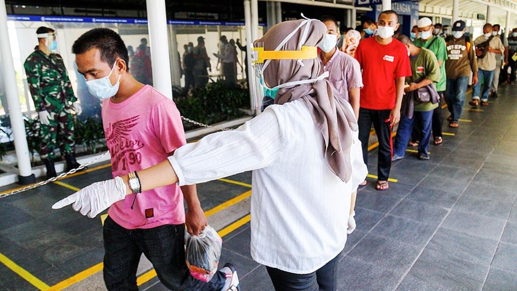 Petugas Kantor Kesehatan Pelabuhan Kelas I Batam mengatur antrean ratusan pekerja migran Indonesia yang tiba di Pelabuhan Internasional Batam Centre, Kota Batam, Kepulauan Riau, Kamis (21/5/2020). Mereka wajib menjalani pemeriksaan kesehatan.