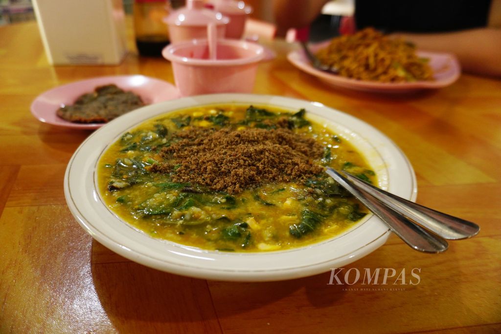 Abon ikan roa di permukaan tinutuan alias bubur manado yang disajikan di Rumah Makan Wakeke, Manado, Sulawesi Utara, Minggu (10/12/2023). Rumah makan tersebut telah berdiri sejak 1991.