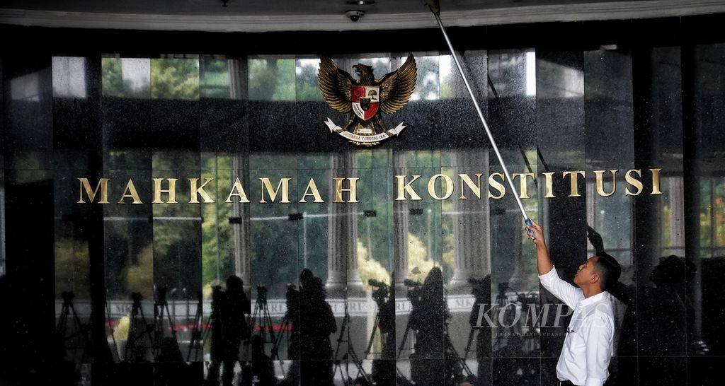 Petugas kebersihan membersihkan langit-langit bagian luar depan ruang sidang saat para hakim konstitusi menggelar rapat penentuan ketua Mahkamah Konstitusi (MK) baru di Gedung Mahkamah Konstitusi, Jakarta, Kamis (9/11/2023). 