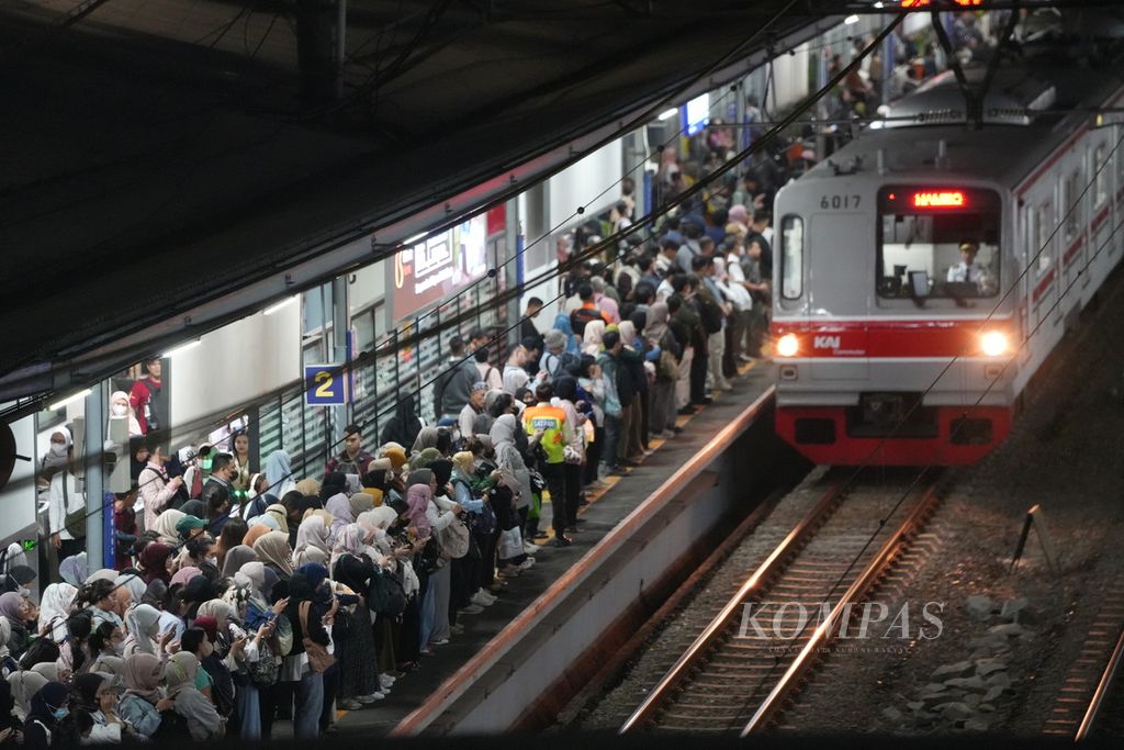 Pekerja kantoran menunggu kedatangan kereta api di Stasiun Cawang, Jakarta Selatan, Senin (24/6/2024).