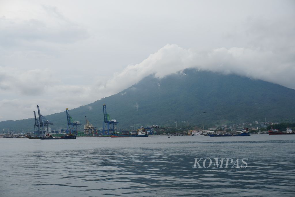 Terminal Peti Kemas Bitung yang berlatar pemandangan Gunung Duasudara dilihat dari Selat Lembeh, Bitung, Sulawesi Utara, Rabu (9/2/2022).