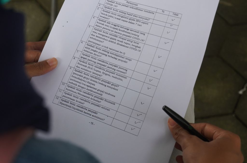 Seorang tenaga kesehatan menjawab pertanyaan terkait kondisi kesehatannya di meja penapisan calon penerima vaksin Covid-19 di Puskesmas Tegal Barat, Kota Tegal, Jawa Tengah, Kamis (28/1/2021). 