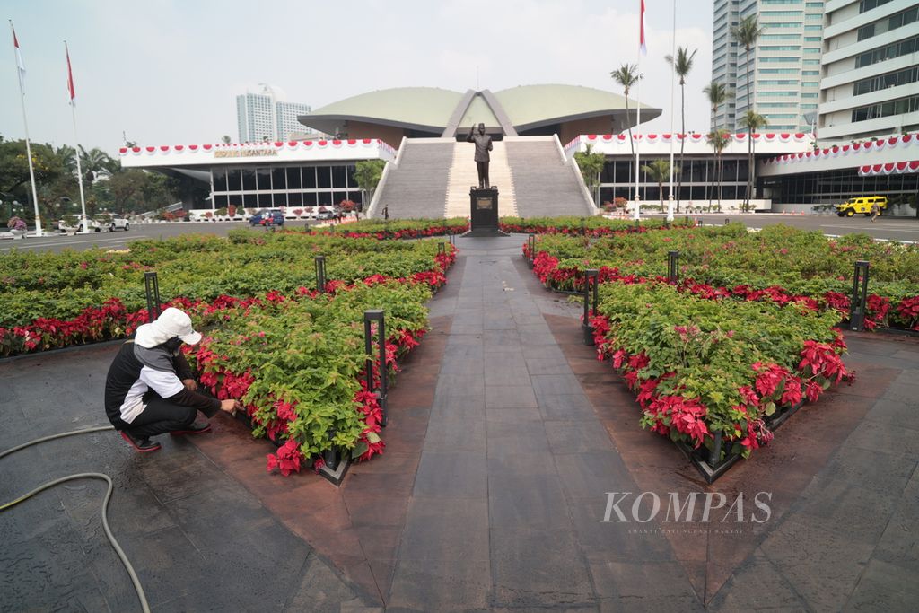 Petugas pertamanan menyirami bunga di taman depan Gedung Nusantara atau Gedung Kura-kura, Kompleks Parlemen, Jakarta, Senin (14/8/2023). 