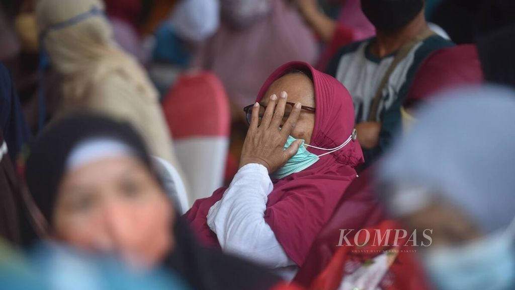 Warga antre saat penyaluran bantuan Program Keluarga Harapan, Bantuan Pangan Non-Tunai, dan Bantuan Langsung Tunai minyak goreng di Kantor Kecamatan Rungkut, Kota Surabaya, Jawa Timur, Sabtu (16/4/2022).
