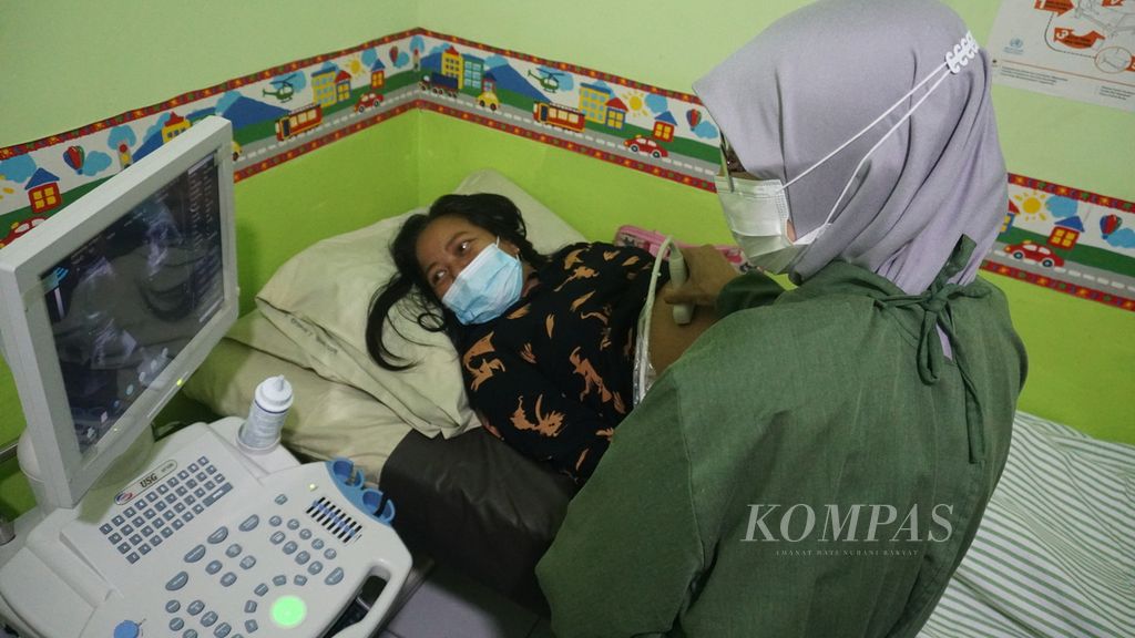 Nining Pujiastuti (41) menatap layar dari hasil pemeriksaan ultrasonografi (USG) yang dilakukan di Puskesmas Sedayu 1, Bantul, Yogyakarta, Jumat (10/2/2023). Pemeriksaan USG amat penting bagi ibu hamil untuk mendeteksi dini gangguan pada kehamilan yang dapat menyebabkan kematian ibu dan bayi. 