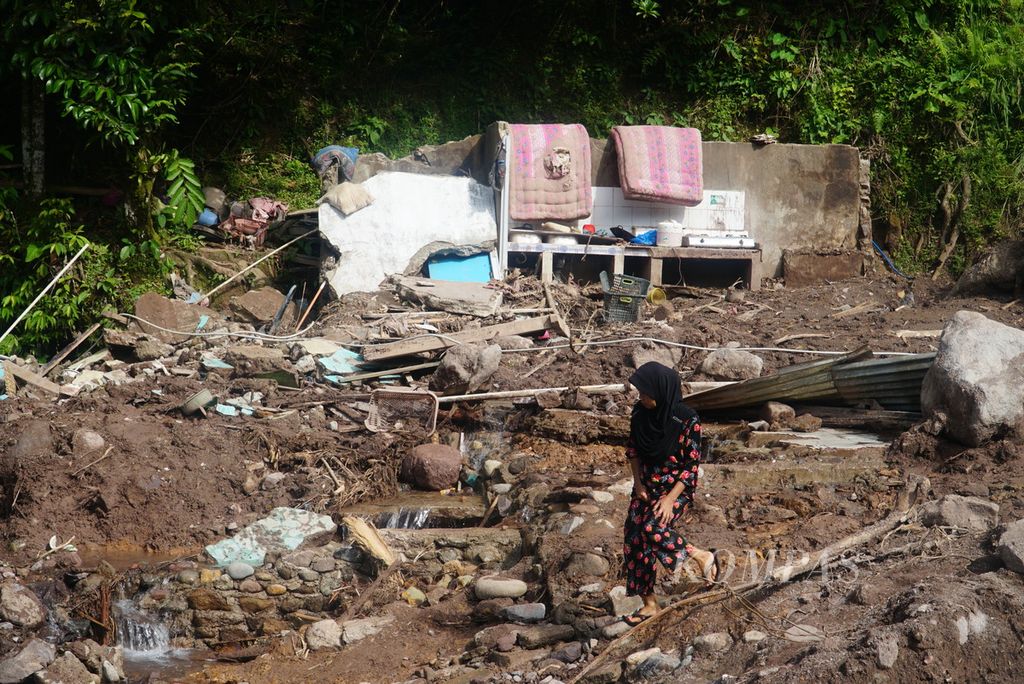 Warga melewati lokasi banjir bandang terparah di Kampung Langgai, Nagari Ganting Mudik Utara Surantih, Kecamatan Sutera, Kabupaten Pesisir Selatan, Sumatera Barat, Kamis (14/3/2024). 