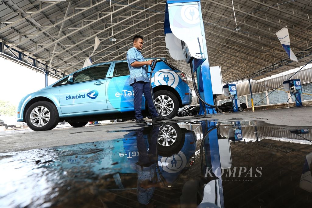 Sopir melakukan pengisian daya listrik pada armada taksi E-Bluebird di Jakarta, Jumat (30/8/2019). 