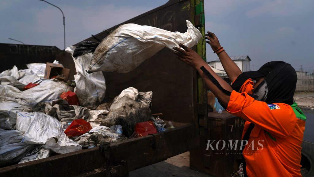 Petugas gabungan Dinas Lingkungan Hidup DKI Jakarta mengumpulkan sampah yang menumpuk di hutan mangrove Muara Angke, Penjaringan, Jakarta Utara, Kamis (13/7/2023). 