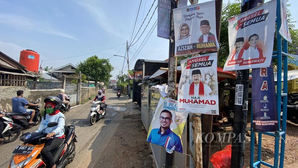 Pengendara melintasi poster pasangan calon wali kota dan wakil wali kota Tangerang Selatan di kawasan Pondok Aren, Tangerang Selatan, Banten, Kamis (1/10/2020). 