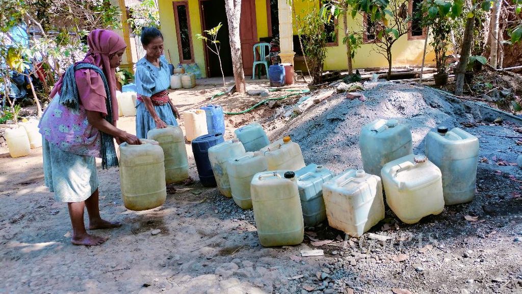Sejumlah warga bersama-sama mengangkat jeriken air dari tangki penampung bantuan air, untuk dibawa ke rumahnya di Dusun Butuh, Desa Candirejo, Kecamatan Borobudur, Kabupaten Magelang, Jumat (22/9/2023).