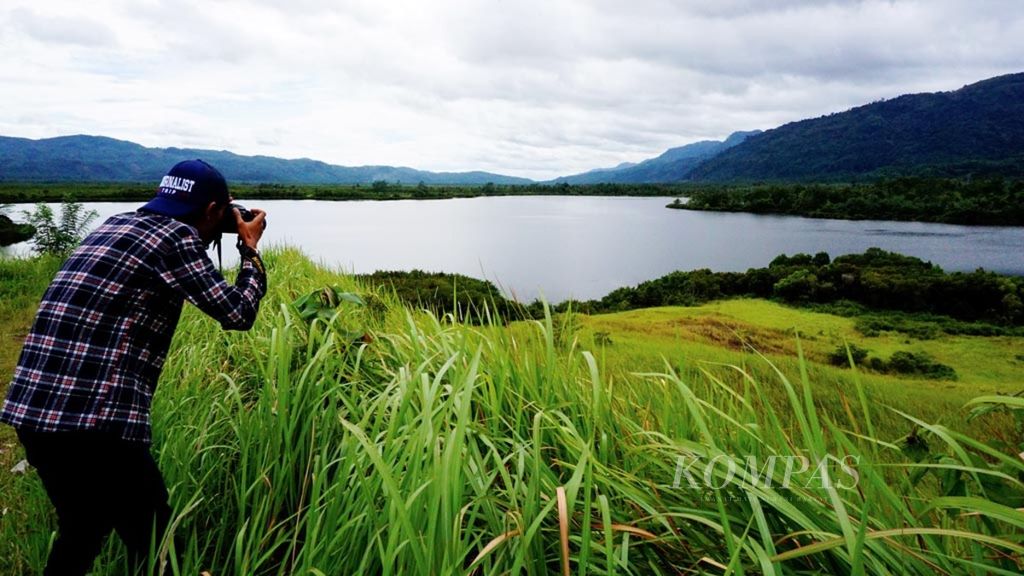 A visitor takes a photo of Lebar Lake located in the utilization zone of Bukit Barisan Selatan National Park, Suoh District, West Lampung Regency, Lampung Province, at the end of November. The lake is being developed into one of the special interest tourism destinations in TNBBS.
