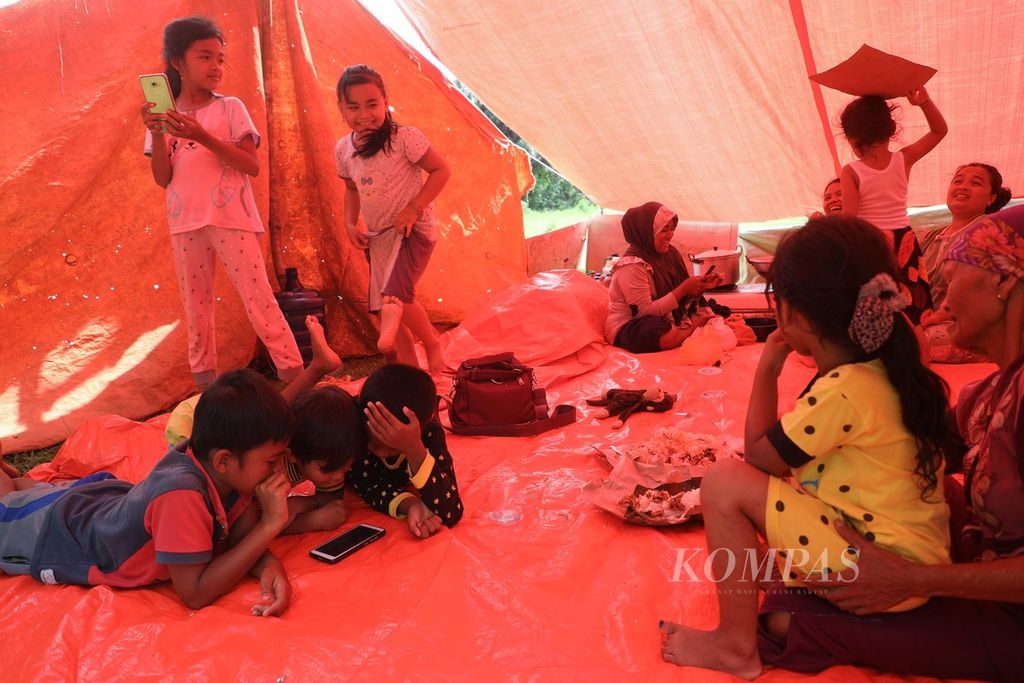 Keluarga pengungsi berada di dalam tenda pengungsian di Nagari Kajai, Kecamatan Talamau, Kabupaten Pasaman Barat, Sumatera Barat, Senin (28/2/2022). 