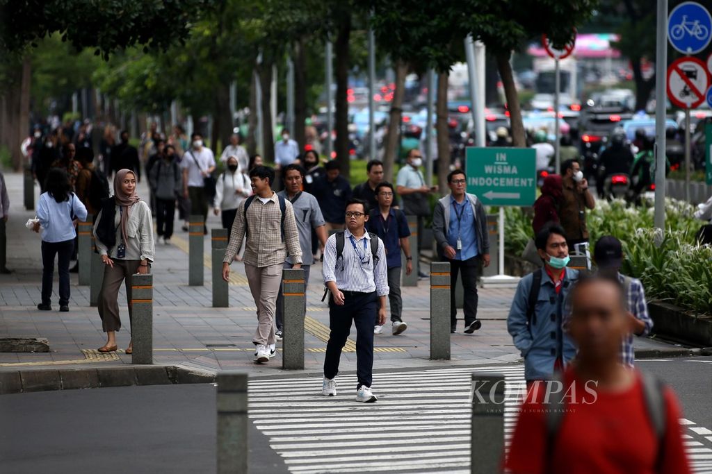 Pekerja kantor berjalan kaki melalui pedestrian Jalan Jenderal Sudirman, Jakarta, saat jam pulang kerja, Rabu (13/3/2024).