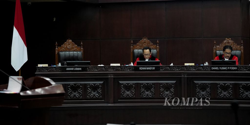 Meja yang ditempati hakim konstitusi Anwar Usman (kiri) kosong karena dia keluar meninggalkan sidang saat Mahkamah Konstitusi menggelar agenda sidang putusan di MK, Jakarta, Kamis (29/2/2024).  