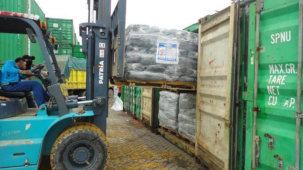 Pekerja memasukkan karet remah ke dalam kontainer di Pelabuhan Belawan, Medan, Sumatera Utara, Sabtu (18/6/2022).