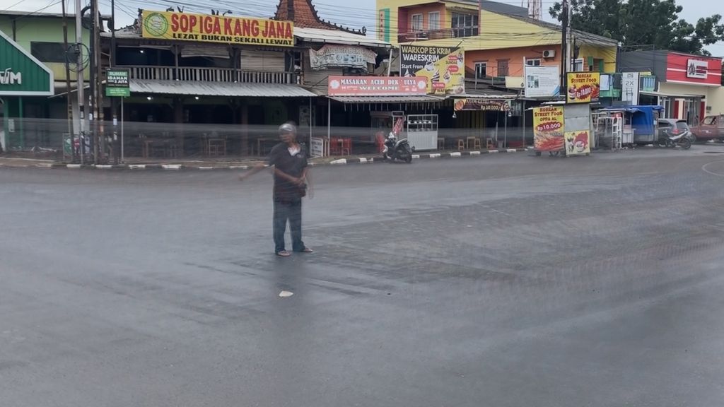 Jafar, seorang "pak ogah" di perempatan Viktor, Serpong, Tangerang Selatan, Kamis (2/3/2023). Pemberlakuan rekayasa lalu lintas sistem satu arah membuat mereka harus menepi.