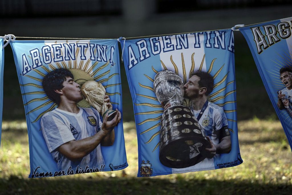 Bendera yang menampilkan sosok Diego Maradona dan Lionel Messi terlihat di lokasi saat para penggemar Argentina menonton pertandingan semifinal Piala Dunia Qatar melawan Kroasia melalui layar besar di Buenos Aires, Argentina, Selasa (13/12/2022). Messi mencatat penampilan ke-25 di Piala Dunia dalam pertandingan melawan Kroasia dengan koleksi 11 gol di ajang Piala Dunia.