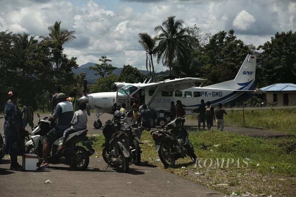 Warga menunggu pesawat perintis yang baru mendarat di Bandara Nduga, Nduga, Papua, Sabtu (16/10/2021). Pusat keramaian kota Kenyam, ibu kota Kabupaten Nduga, berada di ujung jalan menuju landasan pesawat terbang,