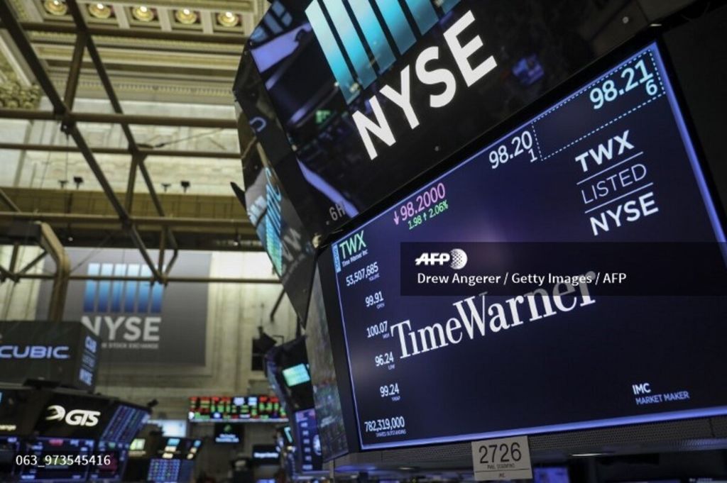 Sebuah logo dan informasi perdagangan untuk Time Warner ditampilkan pada monitor di lantai Bursa Efek New York (NYSE) 13 Juni 2018 di New York City, Amerika Serikat.