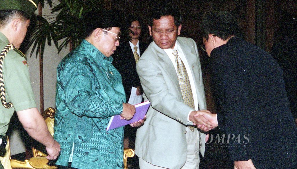 Presiden Abdurrahman Wahid didampingi Menteri Pertahanan Mahfud MD menerima buku dari peserta Kursus Singkat Khusus Angkatan (KSKA) I Lembaga Pertahanan Nasional di Bina Graha, Jakarta, 2 Juli 2001. 