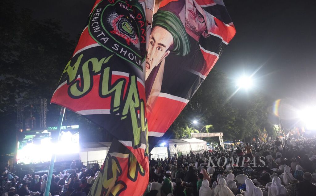 Nahdliyin (NU followers) carry a flag while participating in a ritual in order to welcome the peak reception of the One Century Nahdlatul Ulama (NU), Sidoarjo, East Java, Tuesday (7/2/2023) early morning.