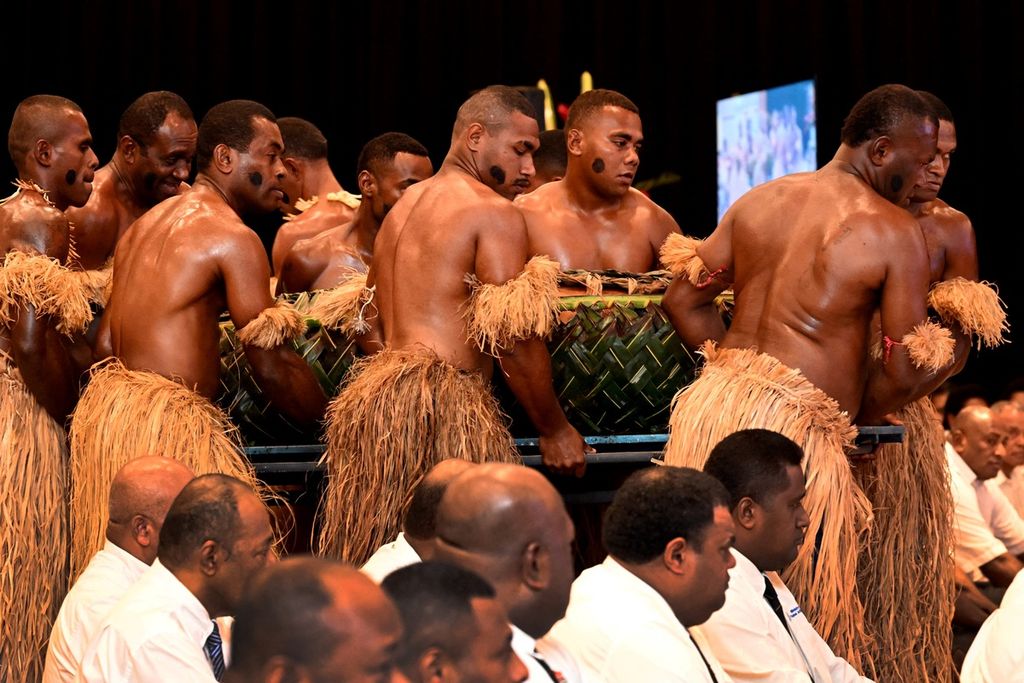 Penari tradisional membawa persembahan saat upacara penyambutan di Forum Kepulauan Pasifik di Suva, Fiji, 12 Juli 2022.  