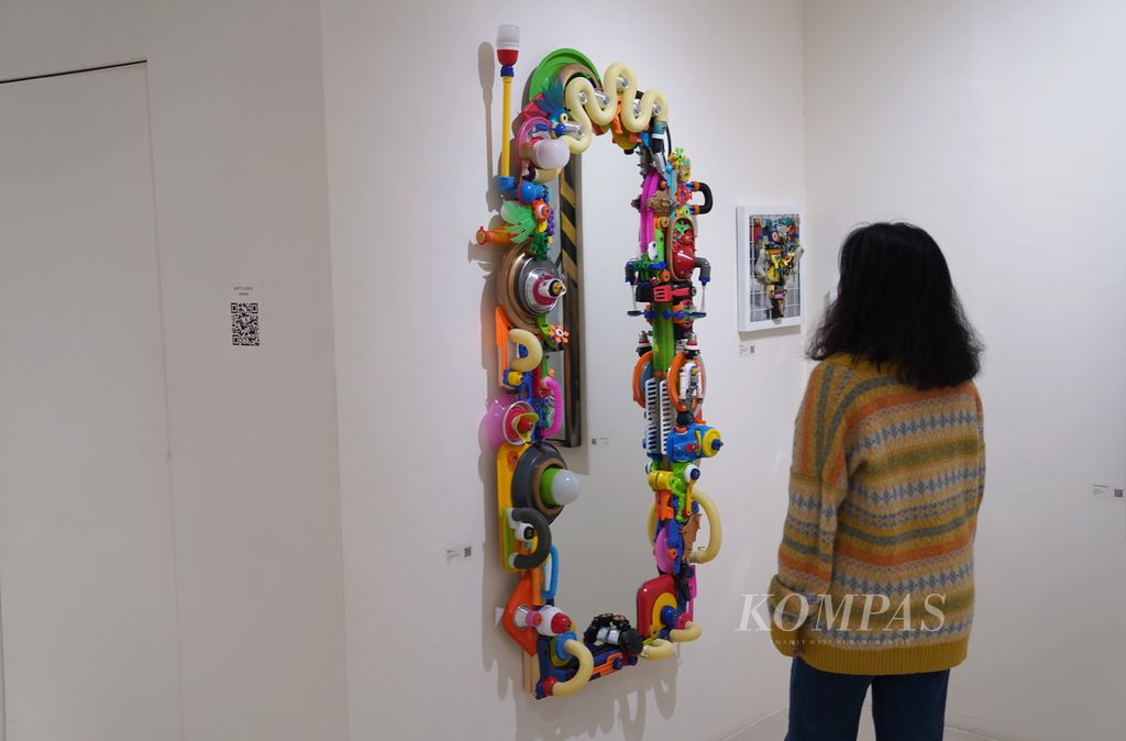 Pengunjung mengamati karya Reexp (Evan dan Attina) yang berjudul ”Dunia dalam Cermin” dalam pameran bertajuk Art Coolture di Jakarta Art Hub, Jakarta Pusat, Selasa (16/1/2024).