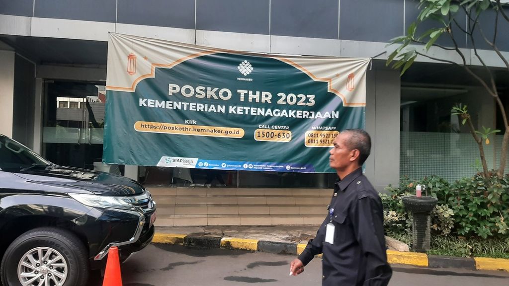 Seorang petugas keamanan melewati depan posko pengaduan THR di Kantor Kementerian Ketenagakerjaan, Jakarta, Kamis (13/4/2023). Menurut Surat Edaran Menteri Ketenagakerjaan Nomor M/2/HK.04.00/III/2023 tentang Pelaksanaan Pemberian Tunjangan Hari Raya Keagamaan Tahun 2023 bagi Pekerja/Buruh di Perusahaan, THR wajib dibayarkan pada 15 April 2023.