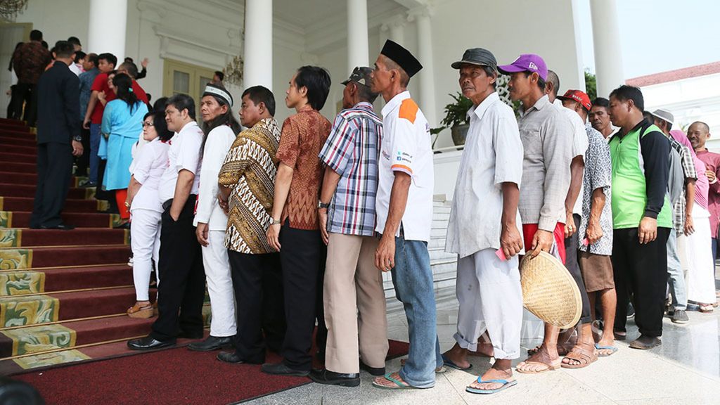 Warga antre untuk bersalaman dengan Presiden Joko Widodo dan Ibu Iriana saat silaturahmi Lebaran 1439 H di Istana Bogor, Jawa Barat, Jumat (15/6/2018). 