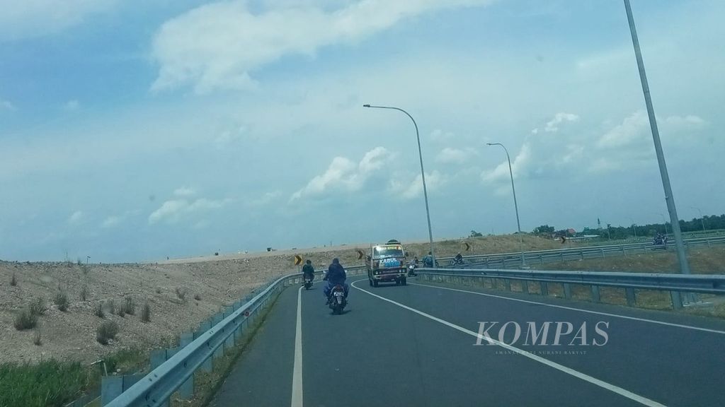 Pengendara sepeda motor melintas di jalan raya yang berada persis di luar kawasan pembangunan Bandara Dhoho di Kabupaten Kediri, Jawa Timur, beberapa waktu lalu.