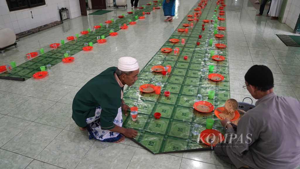 Two man prepare suro porridge for iftar gathering  at the Al Mahmudiyah Mosque or known as the Suro Mosque at 30 Ilir, Ilir Barat II District, Palembang, South Sumatra, Thursday (23/3/2023). During Ramadan, mosque managers make porridge every day and eat it with the congregation when breaking their fast.