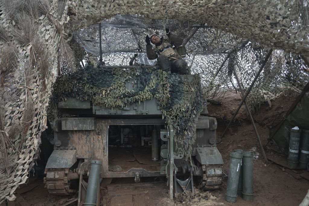 Anggota Pasukan Khusus Ukraina membenahi jaring kamuflase untuk melindungi persenjataan beratnya, M109 Paladin, di sebuah lokasi di Luhansk, Ukraina (28/1/2024). 