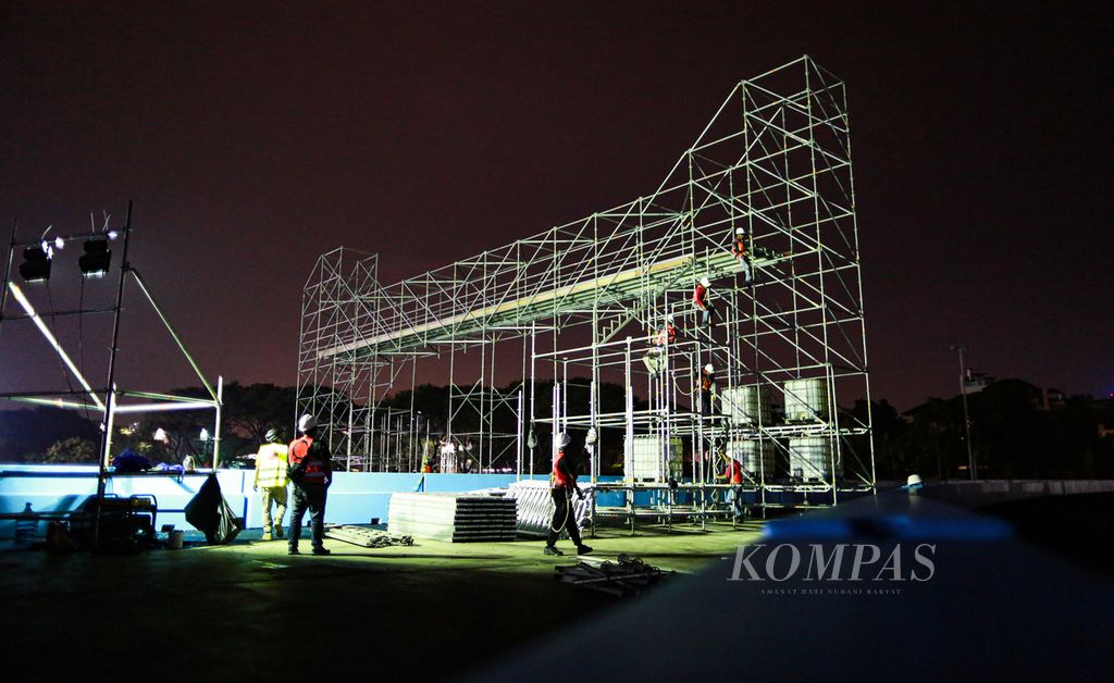 Aktivitas pekerja yang tengah membangun jembatan penyeberangan tepat di posisi garis start pada proyek sirkuit Formula E di kawasan Pantai Karnaval Ancol, Taman Impian Jaya Ancol, Kecamatan Pademangan, Jakarta Utara, Minggu (15/5/2022) malam. Pengerjaan fasilitas pendukung di sirkuit ini berlangsung selama dua pekan ke depan.