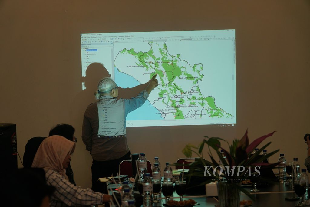Manajer Komunikasi KKI Warsi Rudi Syaf menunjukkan titik lokasi yang kehilangan tutupan hutan di Sumatera Barat, Jumat (23/12/2022), di Padang, Sumbar. Selama 2022, Sumbar kehilangan tutupan hutan seluas 27.447 hektar, antara lain akibat tambang emas ilegal, pembukaan perkebunan masyarakat, dan pembalakan liar.