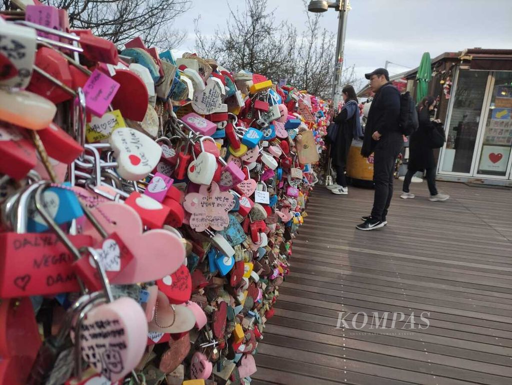 Gembok-gembok dipasang sebagai ungkapan cinta dua sejoli di Seoul, Korea Selatan, Rabu (22/3/2023). Suhu di awal musim semi itu masih termasuk rendah, bisa menyentuh 3 derajat celsius pada pagi hari.
