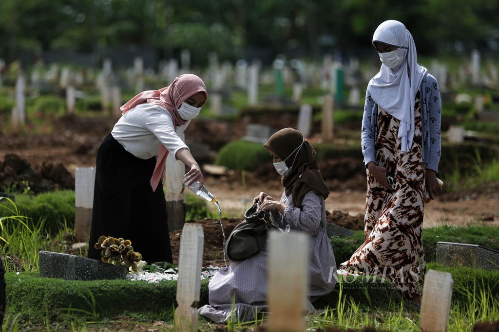 Warga berdoa di depan pusara kerabatnya di Pemakaman Khusus Covid-19 TPU Rorotan, Jakarta, saat hari pertama tahun 2022, Sabtu (1/1/2022).