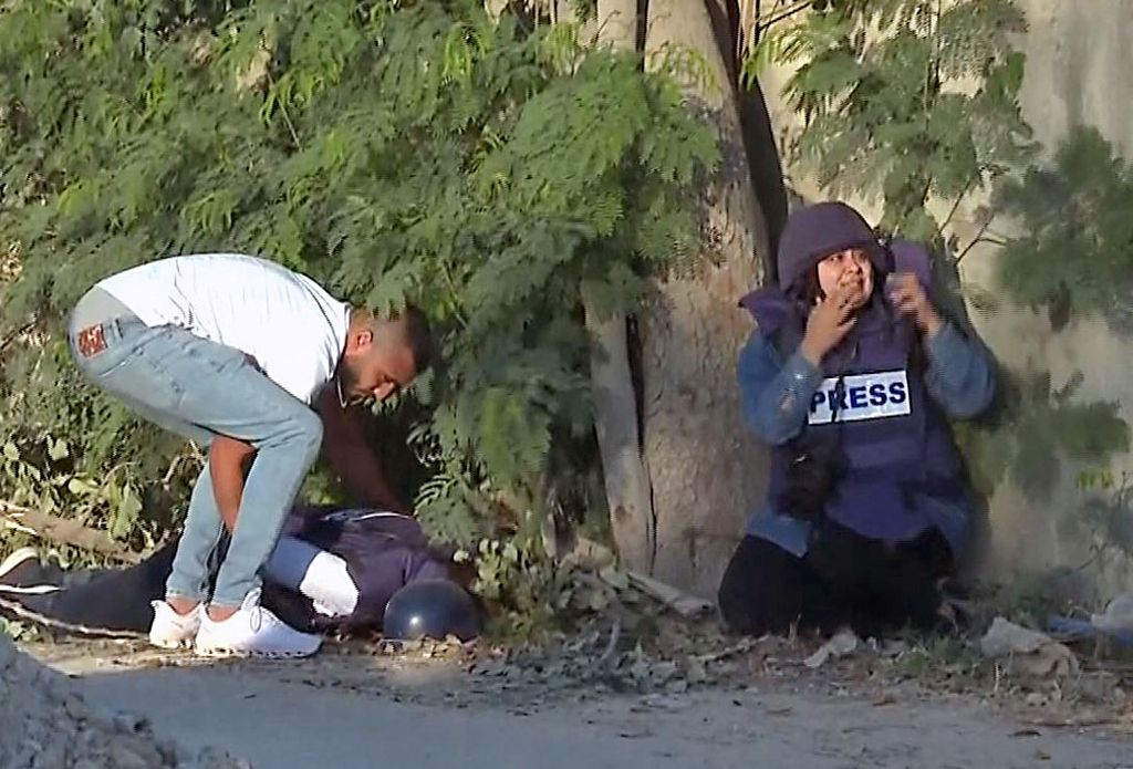 Foto dari tayangan video yang didistribusikan oleh televisi Al Jazeera ini memperlihatkan seorang pria berusaha mengangkat tubuh wartawan Al Jazeera, Shireen Abu Aqleh, yang tewas tertembak di Jenin, wilayah pendudukan Tepi Barat, 11 Mei 2022. 