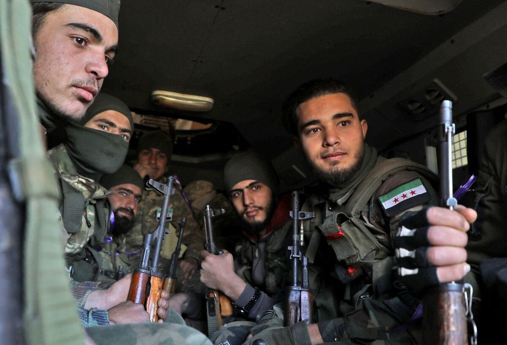 Para anggota milisi Suriah dukungan Turki duduk dalam satu kendaraan di kota Qamina, Provinsi Idlib, Suriah barat laut, 20 Februari 2020.