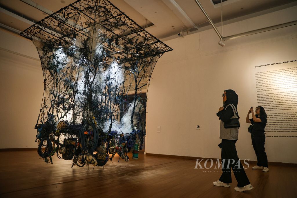 Visitors are observing the installation piece by Iwan Yusuf at the Contemporary Indonesian Art Exhibition: Post-Modern Era at the National Gallery of Indonesia, Jakarta on Friday (29/12/2023). This exhibition showcases works of 12 artists from various disciplinary backgrounds. Running until January 21, 2024, the exhibition aims to showcase the latest developments in Indonesian contemporary art.