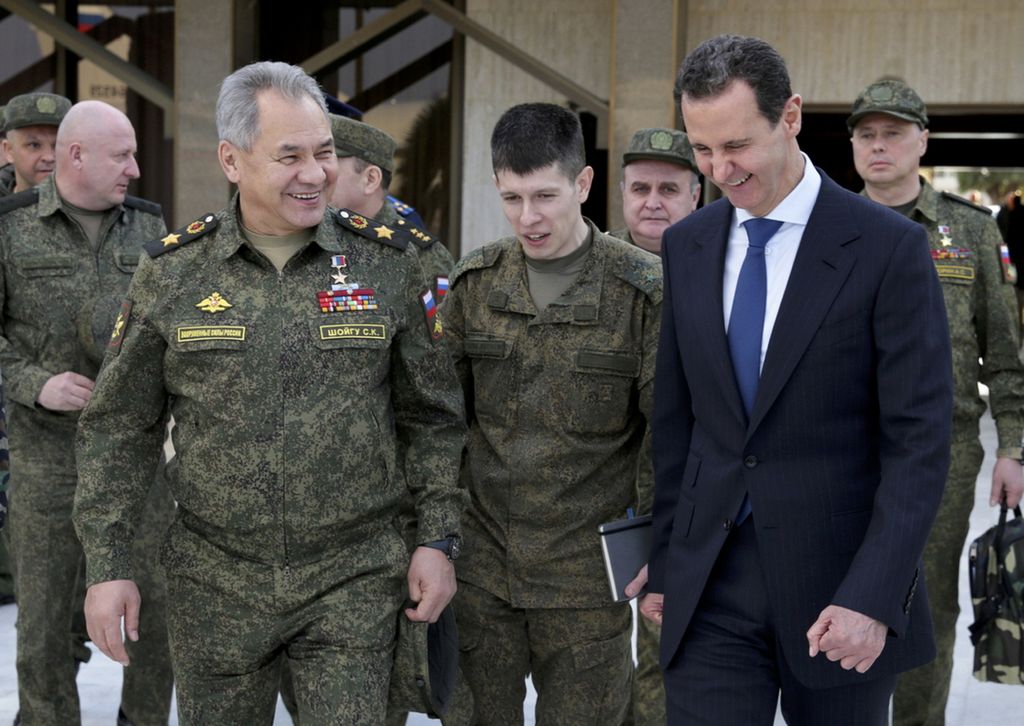 Menteri Pertahanan Rusia Sergey Shoigu (kiri) dan Presiden Suriah Bashar al-Assad tersenyum dalam pertemuan mereka di Damaskus, Suriah, 15 Februari 2022.