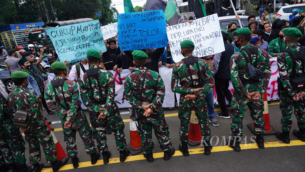 Mahasiswa dari Himpunan Mahasiswa Islam (HMI) berhadapan dengan barikade anggota TNI saat menggelar aksi menolak disahkannya UU Cipta Kerja di depan Istana Bogor, Kota Bogor, Jawa Barat, Rabu (7/10/2020). 